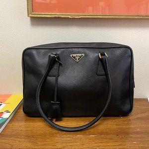 Authenticated Prada Black Saffiano Leather Bauletto Satchel with padlock.